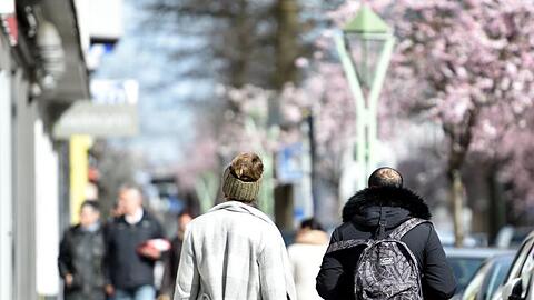 Menschen spazieren in Essen und genießen das sonnige Wetter.