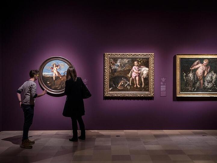 Eine Frau und ein junger Mann stehen vor dem Tizian-Werk "Der Triumph der Liebe" in der Ausstellung "Tizian und die Renaissance in Venedig" im Städel.
