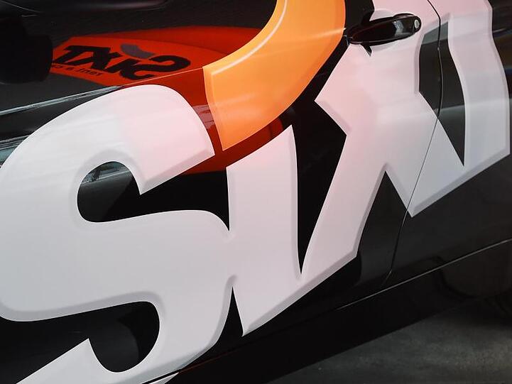 Das Logo des Autovermieters Sixt SE an einer Fahrzeugtür. Foto: Tobias Hase/dpa/Symbolbild