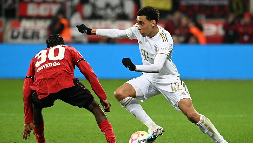 Leverkusens Jeremie Frimpong (l) und Bayerns Jamal Musiala kämpfen um den Ball. Leverkusens Jeremie Frimpong (l) und Bayerns Jamal Musiala kämpfen um den Ball.