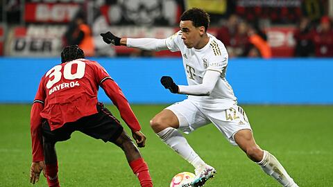 Leverkusens Jeremie Frimpong (l) und Bayerns Jamal Musiala kämpfen um den Ball.
