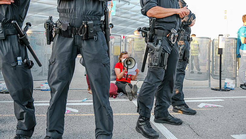 Protestaktion am Einlass vor dem Stadion: Eine Aktivistin von Extinktion Rebellion hat sich an ein Gitter gekettet und verurteilt in einem Plakat die Menschenrechtsverletzungen von EM-Sponsoren. Protestaktion am Einlass vor dem Stadion: Eine Aktivistin von Extinktion Rebellion hat sich an ein Gitter gekettet und verurteilt in einem Plakat die Menschenrechtsverletzungen von EM-Sponsoren.