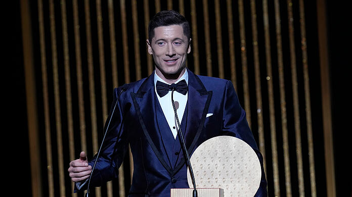 Robert Lewandowski vom FC Bayern mit der Ballon d'Or-Trophäe 2021 für den Stürmer des Jahres.