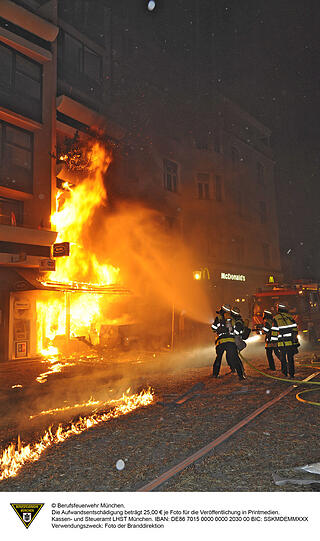 Flammen schlagen aus den Häusern in der Feilitzschstraße, auf dem Boden liegt Stroh, die Feuerwehr löscht.