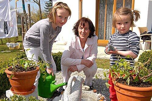 Marlene, Leih-Oma Inge Magg und Emelie (von links): Der kleine Brunnen im Garten der Maggs hat den Mädchen gleich gefallen.