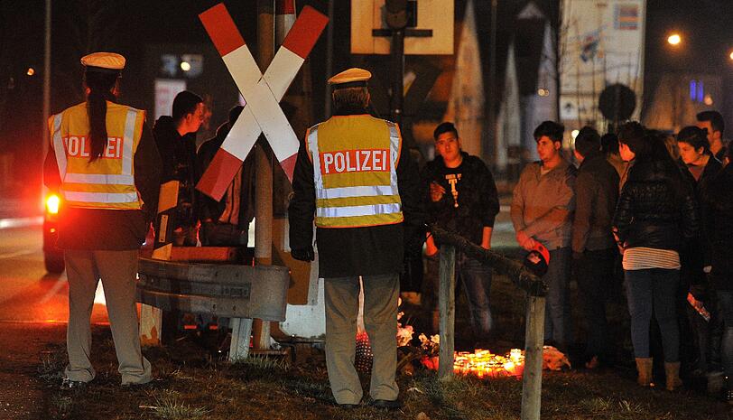 Menschen trauern n Günzburg an einem Bahnübergang. Aus unbekannter Ursache waren dort am 27.12.2012 zwei Mädchen von einem Zug erfasst und getötet worden.