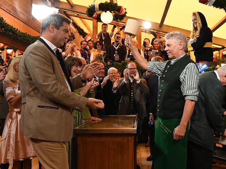 Markus Söder, Ministerpräsident von Bayern, schaut Dieter Reiter, Oberbürgermeister von München, während des traditionellen Fassanstichs zu. Foto: Sven Hoppe