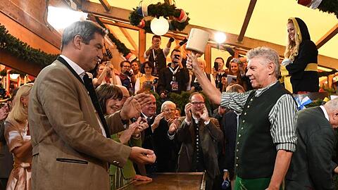 Markus Söder, Ministerpräsident von Bayern, schaut Dieter Reiter, Oberbürgermeister von München, während des traditionellen Fassanstichs zu. Foto: Sven Hoppe