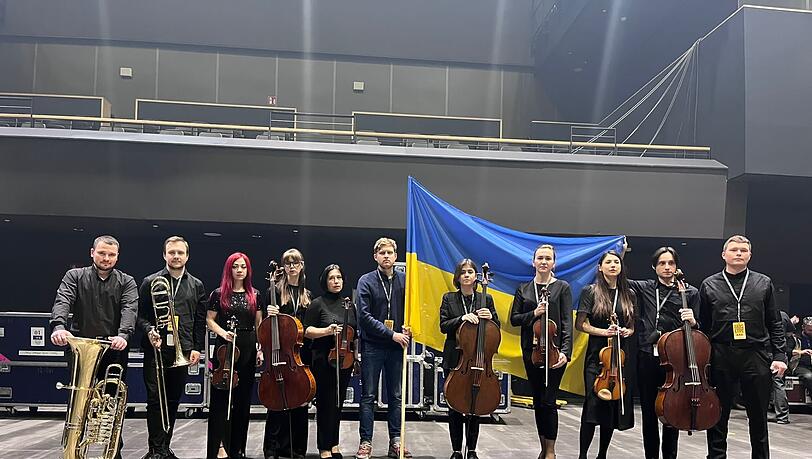 Ukrainische Musiker des Odessa Opera Orchestra mit Tourmanager Oleksandr Lysiuk (M), aufgenommen am Rande einer Probe.