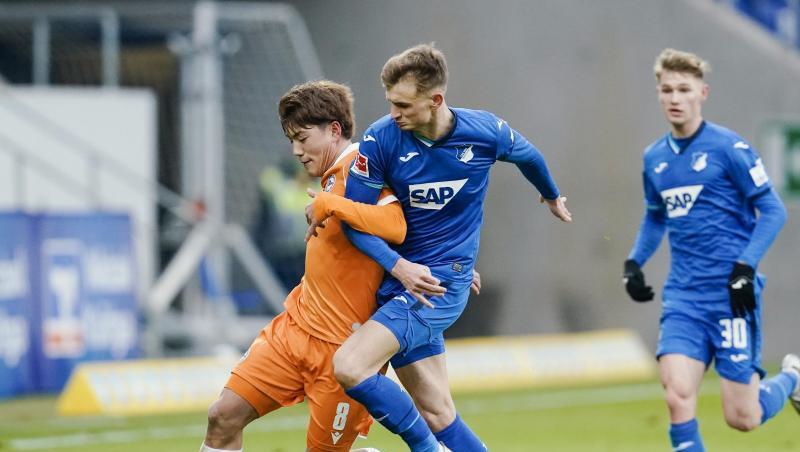 Bielefelds Ritsu Doan (l) stellt im Zweikampf um den Ball geschickt die eigene Schulter vor Hoffenheims Stefan Posch.