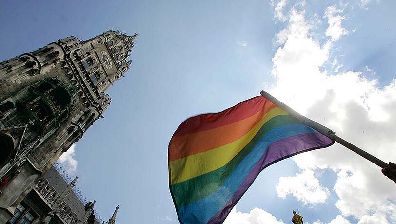 Im Zeichen der Prideweek: Beim CSD 2014 schwenkt ein Parade-Teilnehmer die Regenbogenflagge vor dem Rathaus.