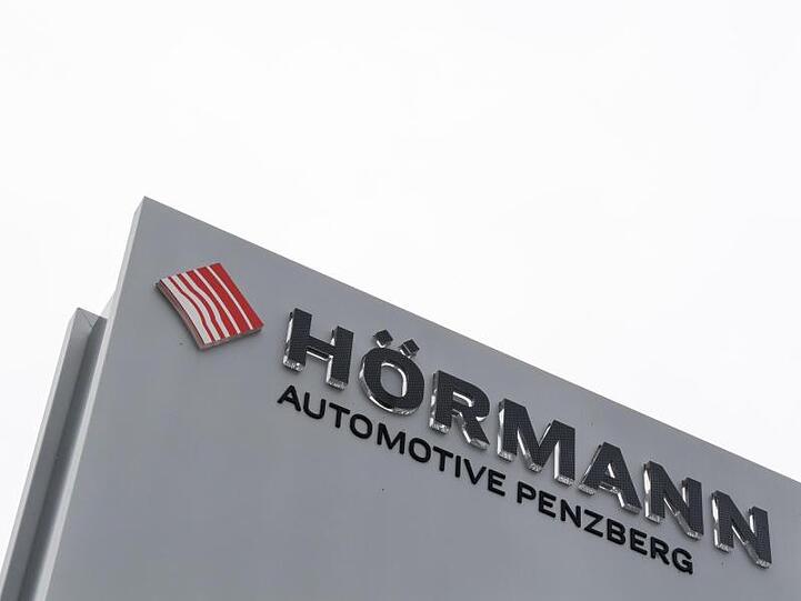 Ein Schild mit der Aufschrift "Hörmann - Automotive Penzberg" steht am Werkseingang. Foto: Peter Kneffel