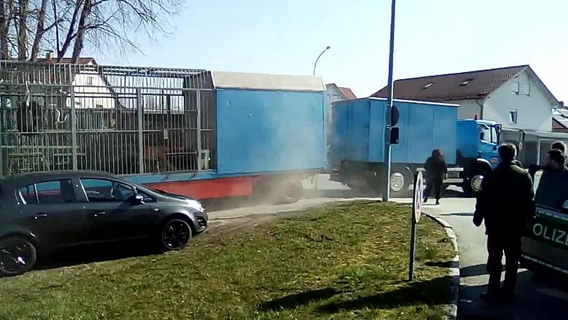 Der Fluchtversuch: Am Steuer des hellblauen Lkw sitzt ein Zirkus-Mitarbeiter. Bens Wagen hat er an den Laster angehängt - mitsamt dem Bären. Gerade hat das Gespann einen Zaun umgewalzt.