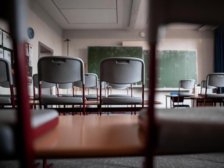 Stühle stehen auf den Tischen in einem leeren Klassenzimmer. Foto: Fabian Strauch/dpa/Archivbild