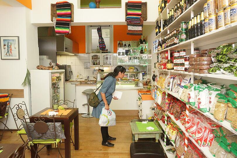 Eine Südamerikanerin steht staunend vor dem Regal mit Produkten aus ihrer Heimat.