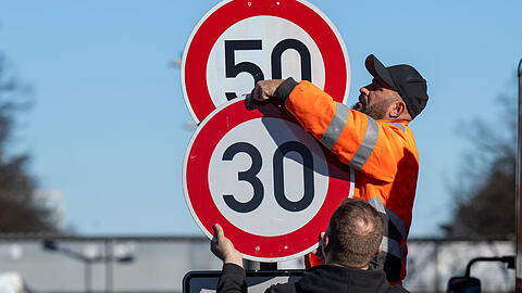 Arbeiter montieren ein Tempo-30-Schild an der Landshuter Allee an. Damit gilt auf dem Mittleren Ring in diesem Abschnitt ab sofort wieder eine H&ouml;chstgeschwindigkeit von 30 Kilometern pro Stunde. M&uuml;ssen sie diese schon bald wieder umh&auml;ngen?
