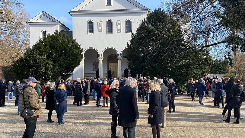 Schon rund 150 Menschen warten rund eine Stunde vor Beginn der Trauerfeier am Münchner Ostfriedhof.