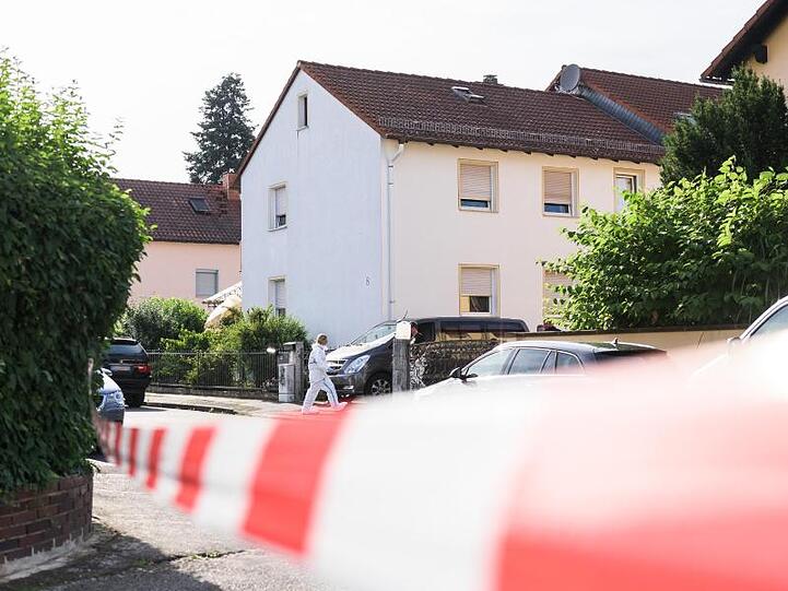Eine Mitarbeiterin der Spurensicherung steht vor einem Einfamilienhaus. Foto: Silas Stein