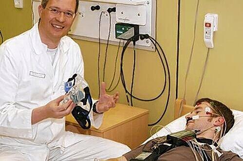 Schlafmediziner Prof. Joachim Ficker setzt einer Patientin im Schlaflabor eine Nasenmaske auf, die Atemaussetzern entgegenwirkt.
