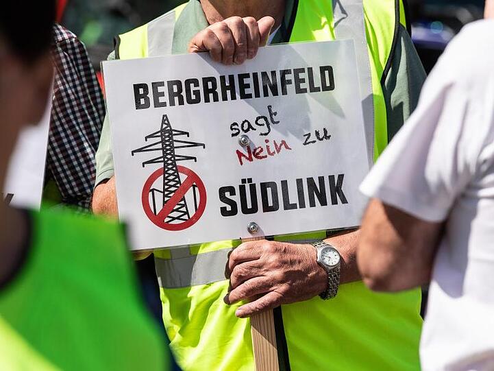 Ein Teilnehmer der Demonstration gegen die geplante Suedlink-Stromtrasse hält ein Transparent mit der Aufschrift "Bergrheinfeld sagt nein zu Südlink" hoch. Foto: Swen Pförtner