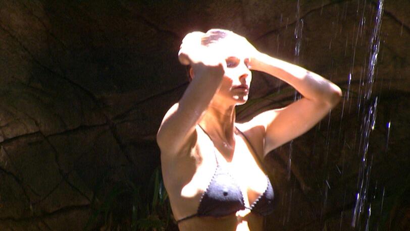 Claudelle Deckert duscht unter dem Wasserfall.