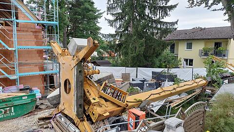 Der umgekippte Baukran: ein Haus, eine Garage und eine Stromleitung sind beschädigt worden. Die Ursache für das Unglück untersucht die Polizei.