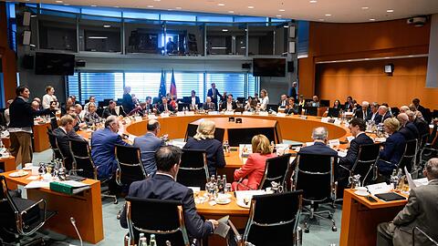 Mitglieder der Bundesregierung und der Ministerpräsidentenkonferenz sitzen zu Beginn des Bund-Länder-Gipfels im Bundeskanzleramt.
