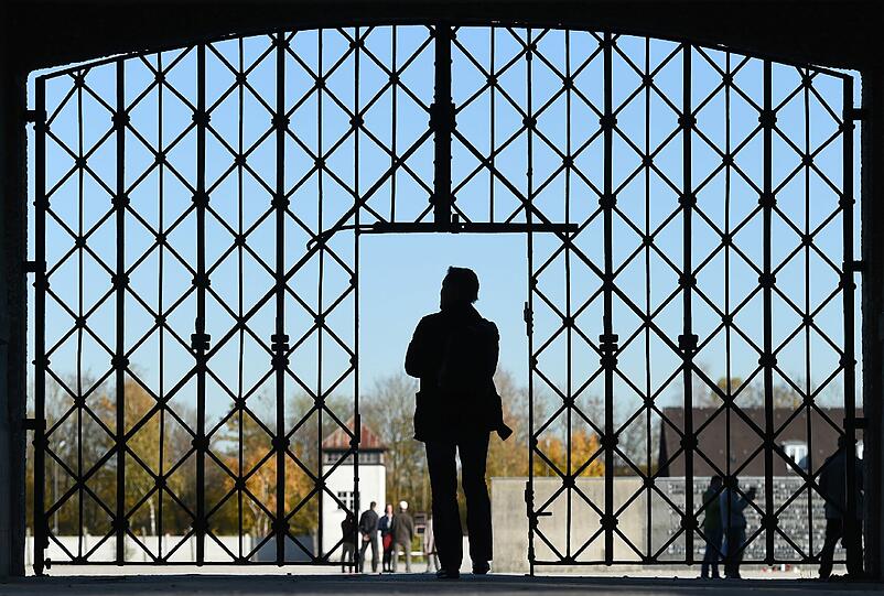 Ein Mann geht am durch das Tor zur KZ-Gedenkstätte in Dachau, wo Unbekannte die Tür mit der Aufschrift "Arbeit macht frei" geklaut haben.
