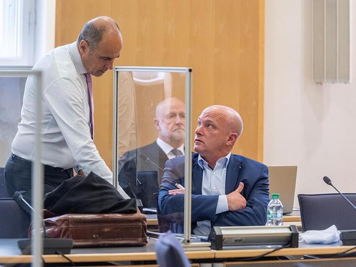 Joachim Wolbergs (r), Regensburger Ex-Oberbürgermeister, spricht im Verhandlungssaal des Landgerichts hinter einer Trennwand aus Plexiglas mit seinem Verteidiger Peter Witting. Foto: Armin Weigel/dpa