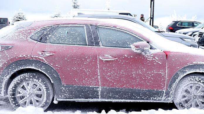 Ein mit Frost überzogenes parkendes Auto auf dem Fichtelberg. Zahlreiche Urlauber haben den Schneefall am Ende der Weihnachtsferien für den Wintersport genutzt.
