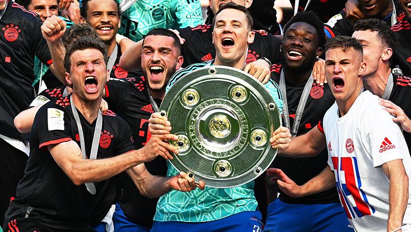 Bayerns Torhüter Manuel Neuer (M) und seine Teamkollegen jubeln nach dem Gewinn der 33. deutschen Meisterschaft mit der Meisterschale.