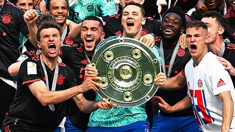 Bayerns Torhüter Manuel Neuer (M) und seine Teamkollegen jubeln nach dem Gewinn der 33. deutschen Meisterschaft mit der Meisterschale.