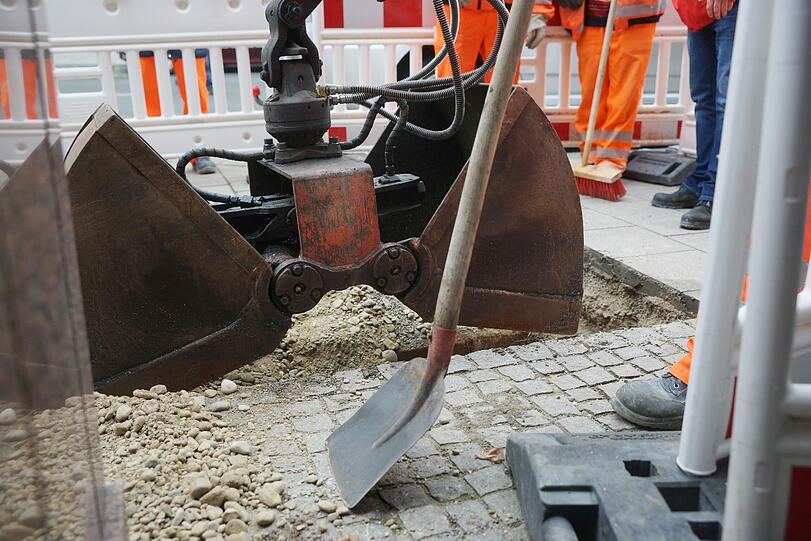 Mitarbeiter des Baureferats verfüllen den Schacht mit viel Kies und Beton.