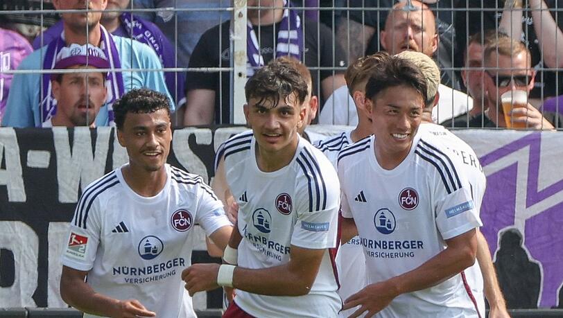 Nürnbergs Torschütze Can Uzun (M) feiert seinen Treffer zum 0:1 mit Nathaniel Brown (l) und Daichi Hayashi.