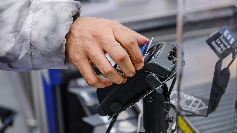 Ein Geflüchteter aus Syrien kauft mit der Social Card für Asylsuchende in einem Supermarkt ein.