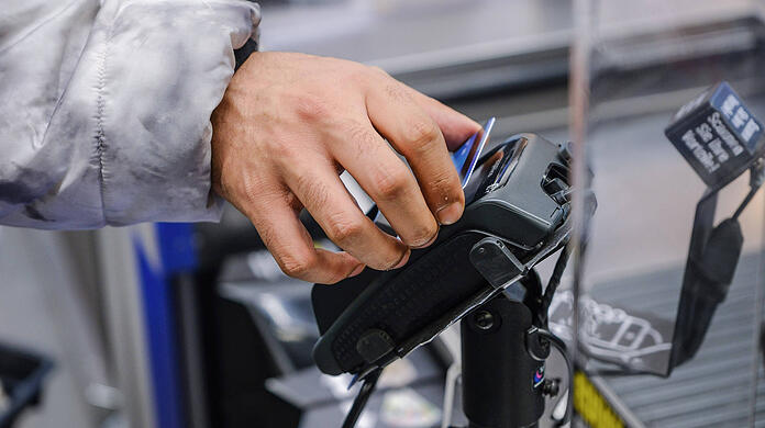 Ein Geflüchteter aus Syrien kauft mit der Social Card für Asylsuchende in einem Supermarkt ein.