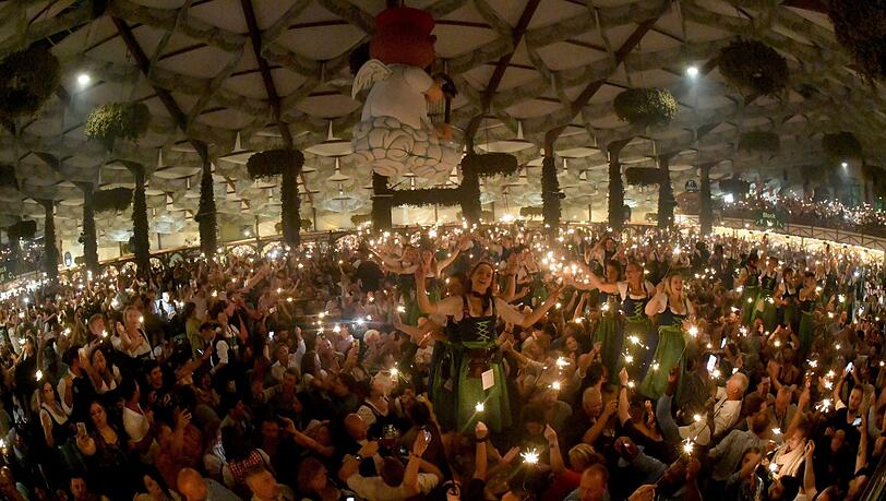 Bedienungen und Gäste feiern mit Wunderkerzen beim traditionellen Kehraus im Hofbräuzelt den Abschluss der Wiesn.