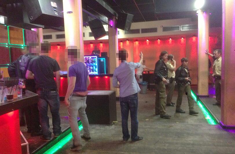 Party-Pause: Polizisten in Uniform befragen auf der Tanzfläche Gäste und Mitarbeiter und notieren sich Personalien.