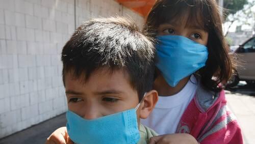 Es trifft die Jungen, die Gesunden. Kimnder mit Mundschutz in Mexiko-Stadt Es trifft die Jungen, die Gesunden. Kimnder mit Mundschutz in Mexiko-Stadt