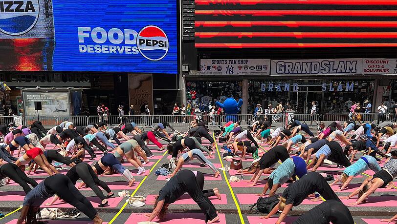 Trotz Hitzewelle versammeln sich Hunderte für Yoga auf dem Times Square.