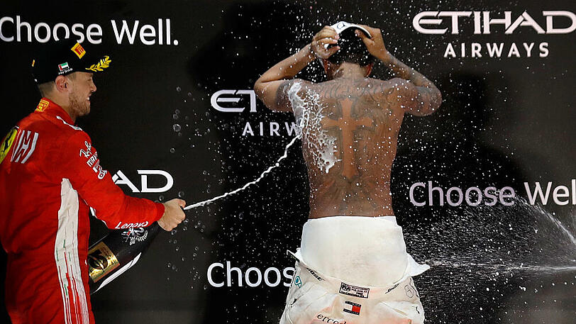 Der Zweitplatzierte Sebastian Vettel (links) mit Abu-Dhabi-Sieger und Weltmeister Lewis Hamilton.