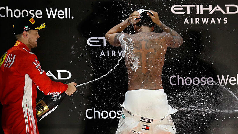 Der Zweitplatzierte Sebastian Vettel (links) mit Abu-Dhabi-Sieger und Weltmeister Lewis Hamilton. Der Zweitplatzierte Sebastian Vettel (links) mit Abu-Dhabi-Sieger und Weltmeister Lewis Hamilton.