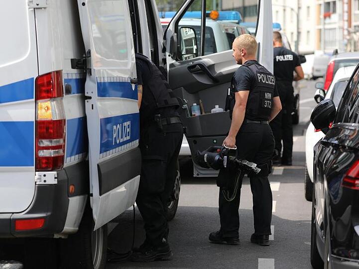 Polizisten mit Werkzeug nach der Durchsuchung.