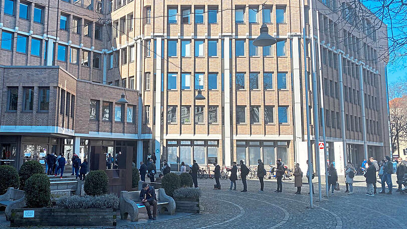 Menschen stehen vor der Arbeitsagentur an der Kapuzinerstraße an.