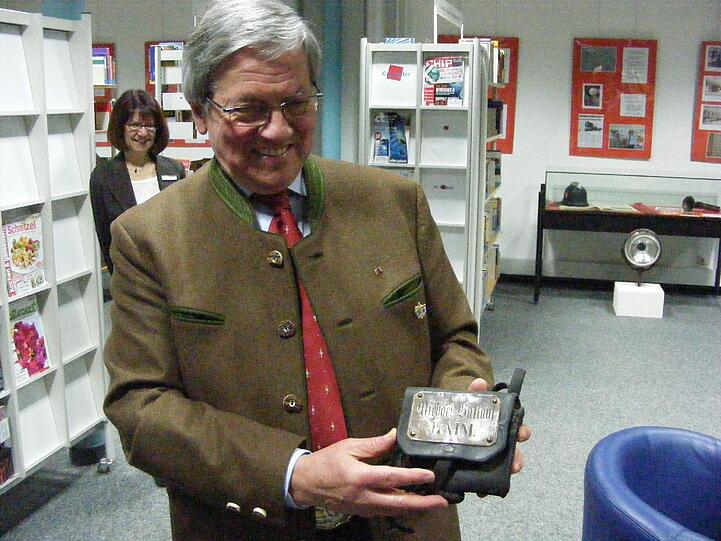 Vorstandsmitglied Josef Kirchmeier vom Historischen Verein Laim freut sich über das Geschenk von Rudolf Ballauf: Die Gürteltasche der FFW Laim seines Großvaters Michael Ballauf.