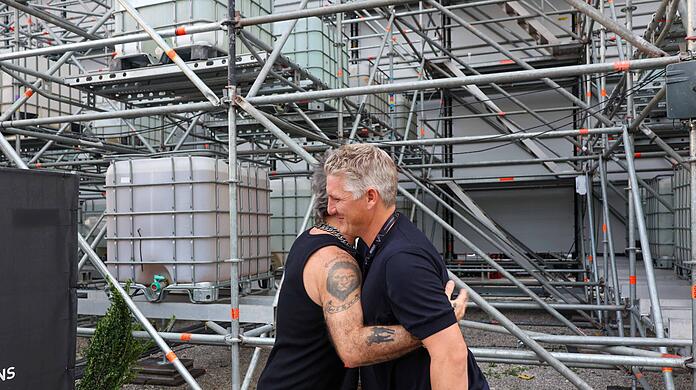 Robbie Williams umarmt  Bastian Schweinsteiger vor seinem Konzert
