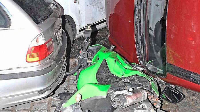 Ein Auto fährt in einer Kurve in geparkte Fahrzeuge, der Fahrer verletzt sich leicht.