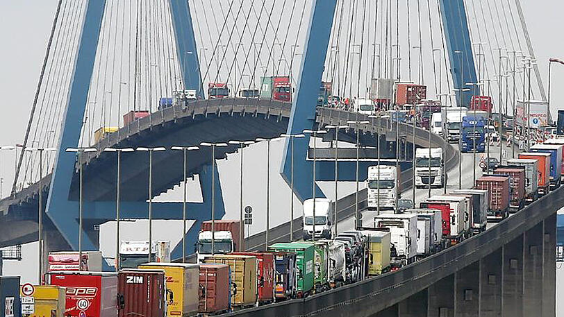 Mit Containern beladene Lastwagen stauen sich am auf der Köhlbrandbrücke im Hafen von Hamburg.
