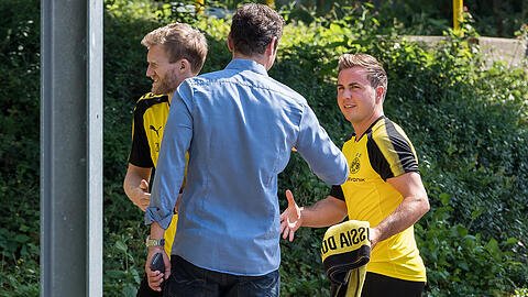 Die Dortmunder Profis André Schürrle (links) und Mario Götze werden auf dem Weg zum Laktattest von BVB-Pressesprecher Sascha Fligge (Mitte) begrüßt.