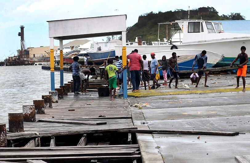 Menschen räumen in Havana, Antigua und Barbuda, Teile eines zerstörten Docks auf.